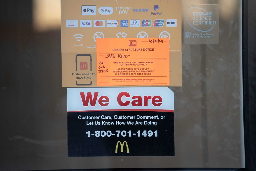 An "unsafe structure notice" is attached to the front door after a vehicle crash caused a hole in McDonald