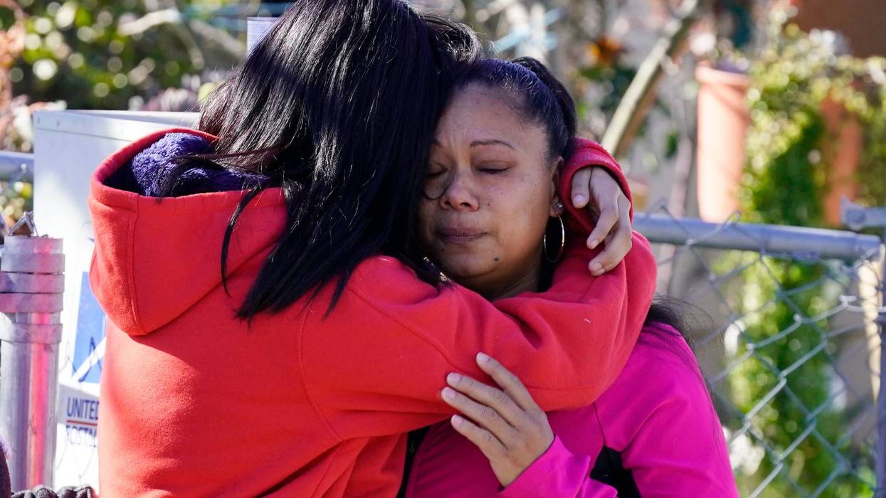 Ana DeJesus, right, is comforted by her daughter, Lizbeth DeJesus after placing a teddy bear and flowers on a memorial at The Church in Sacramento, Calif., on Tuesday, March 1, 2022. Authorities say a man shot and killed his three daughters, their chaperone and himself during a supervised visit with the girls at the church on Monday.