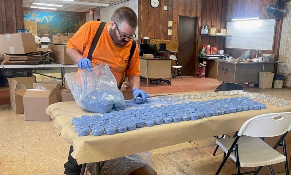 Andrew Ashelman fills jars with milk paint at Scenic River Industries Inc., a sheltered workshop in Salem. A fire destroyed the workshop