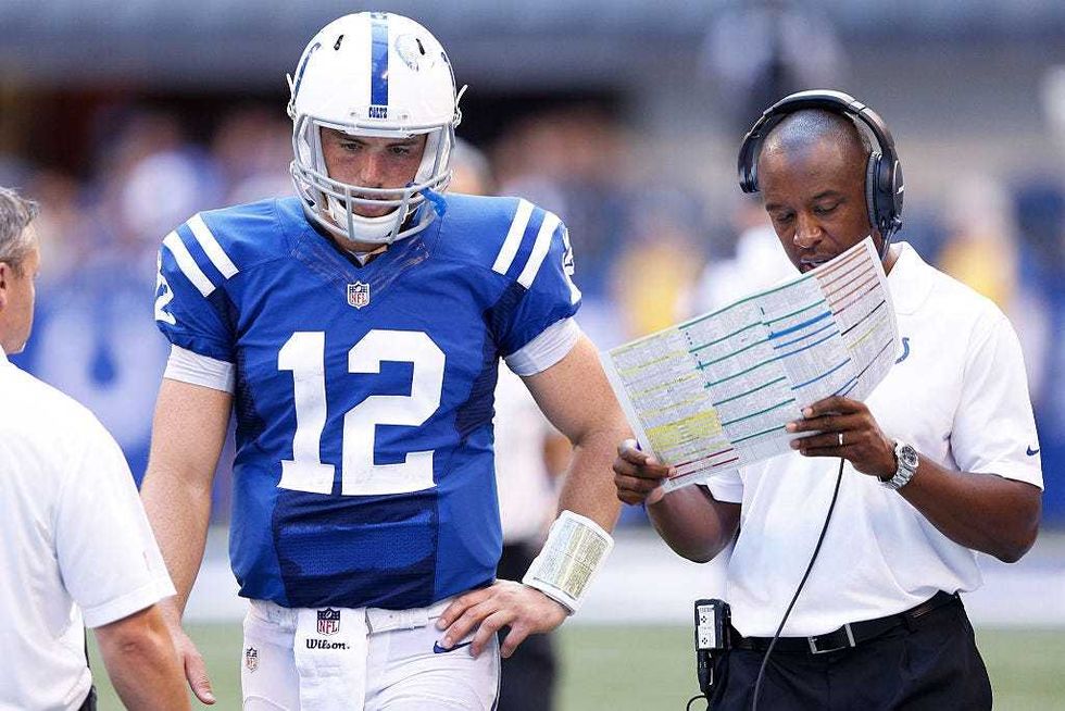 Andrew Luck of the Indianapolis Colts listens to offensive coordinator Pep Hamilton during the game against the Tennessee Titans at Lucas Oil Stadium on September 28, 2014 in Indianapolis, Indiana. The Colts defeated the Titans 41-17.