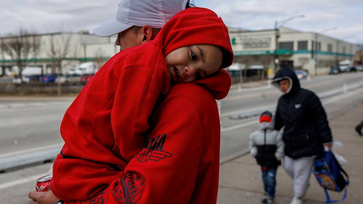 Angel Cardena, 25, holds his 3-year-old son Yulian Cardena outside a migrant shelter on the Lower West Side on Wednesday, Feb. 28, 2024, in Chicago.