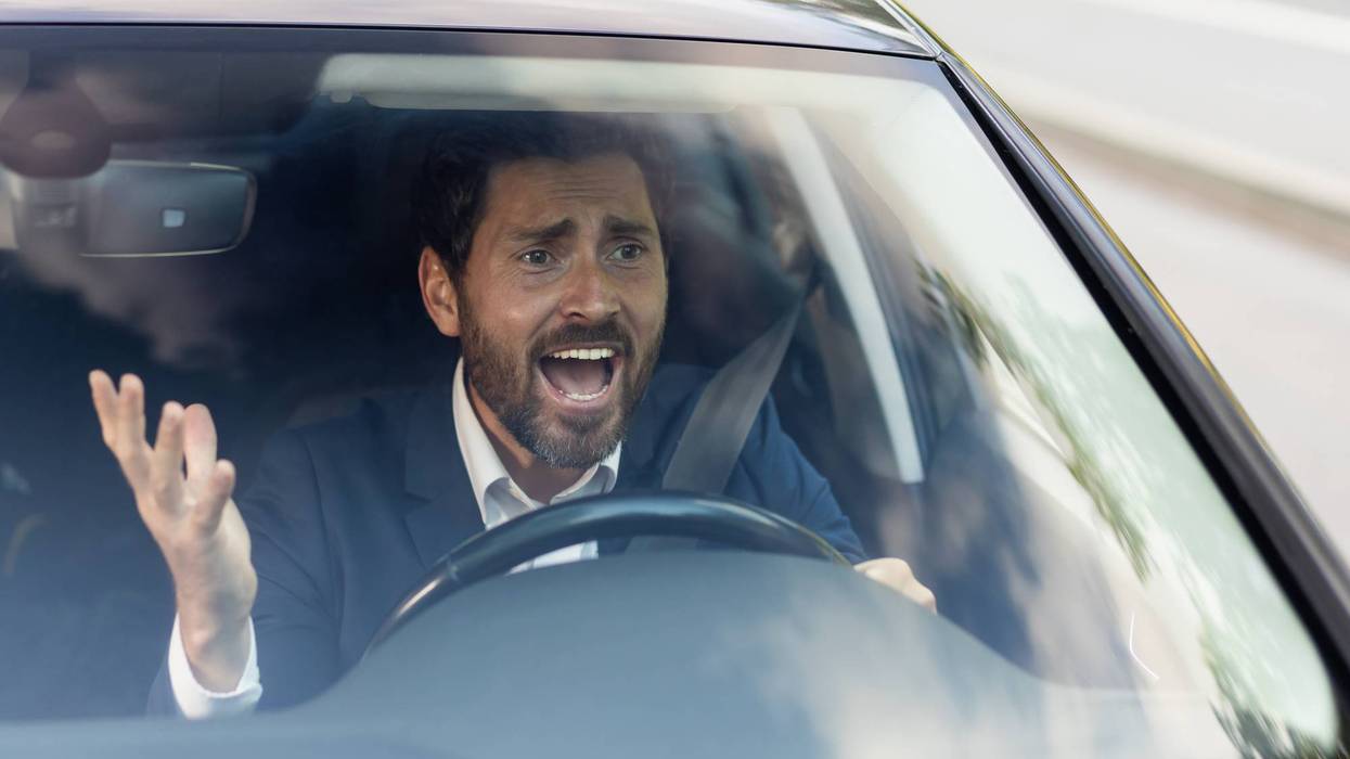 Angry male car driver yells at other drivers and pedestrians who obstruct traffic, mature adult businessman in a business suit is late for a business meeting in a car