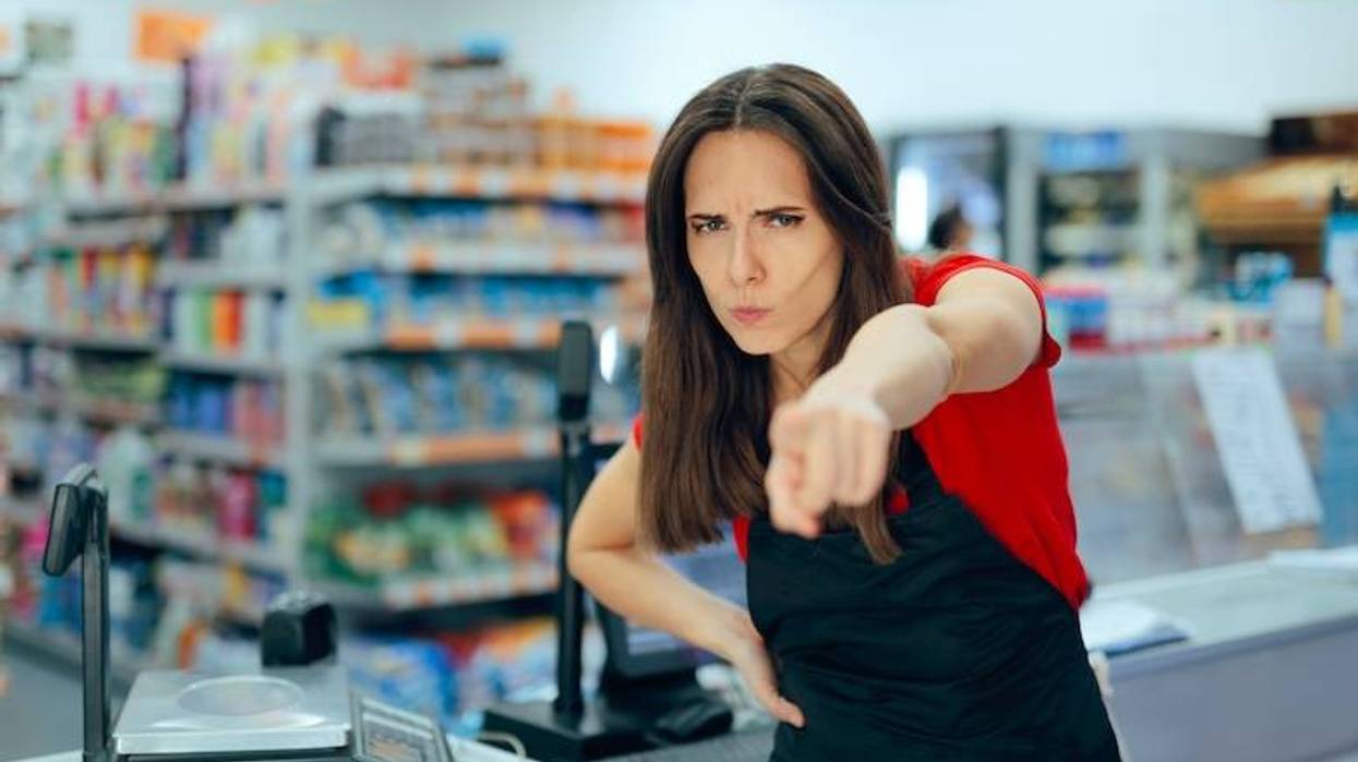 Angry supermarket cashier pointing her finger to the door