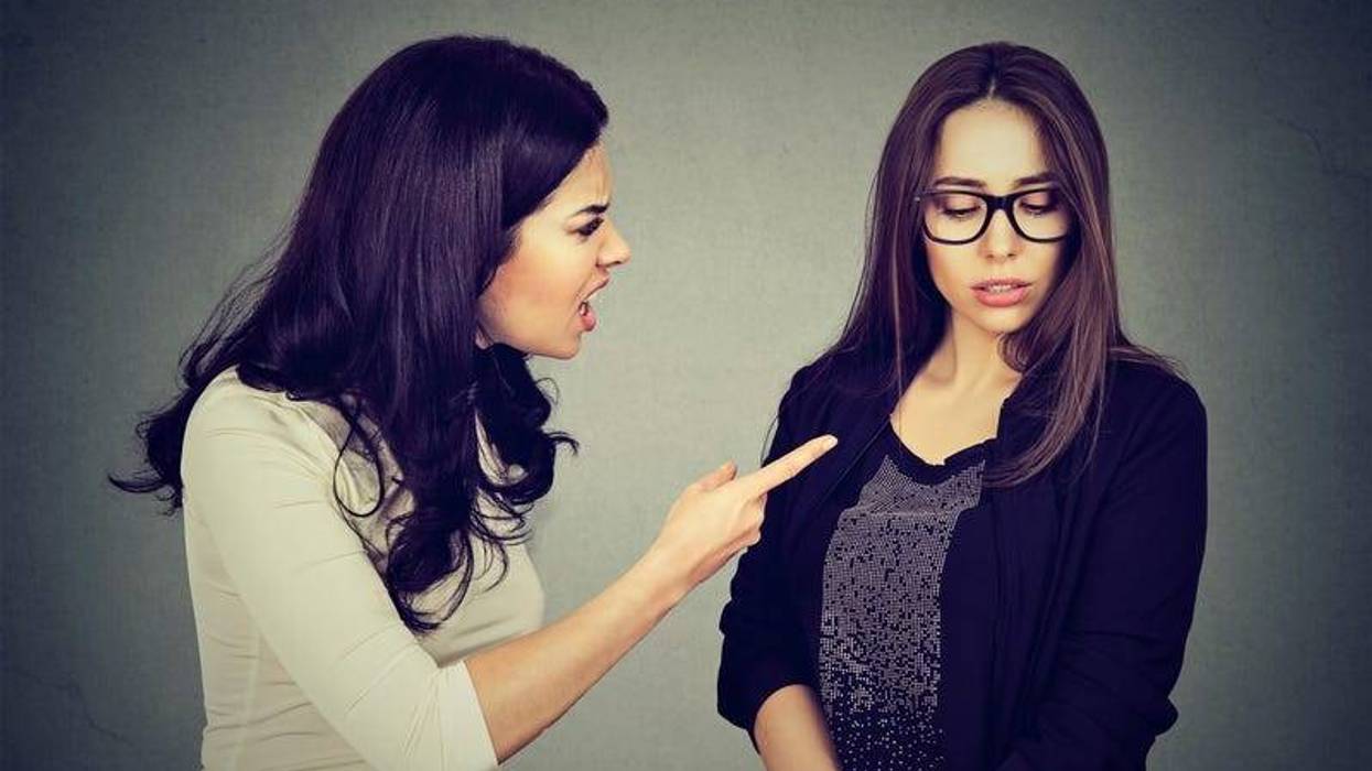 Angry woman scolding her scared shy sister or friend.