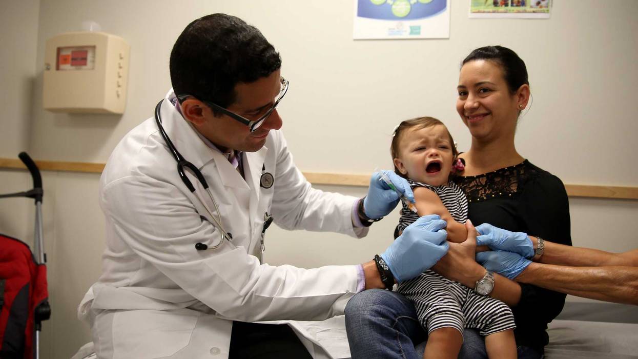 aniela Chavarriaga holds her daughter, Emma Chavarriaga, as pediatrician Jose Rosa-Olivares, M.D. administers a measles vaccination during a visit to the Miami Children's Hospital on June 02, 2014 in Miami, Florida.