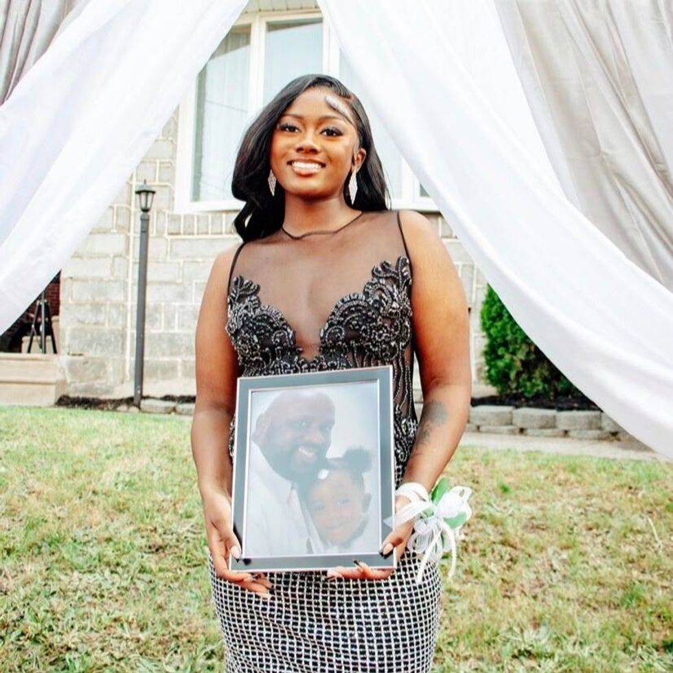 Aniyah holds an image of her father, who died when she was a little girl.