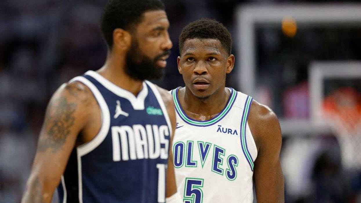 Anthony Edwards #5 of the Minnesota Timberwolves looks at Kyrie Irving #11 of the Dallas Mavericks during the first quarter in Game One. They'll stare each other down all series.