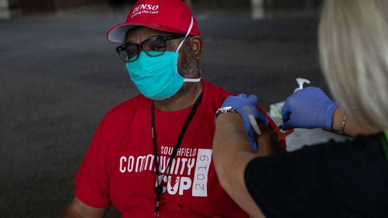 Anthony Faulkner receives his booster dose of the Moderna coronavirus (COVID-19) vaccine during an Oakland County Health Department vaccination clinic at the Southfield Pavilion on August 24, 2021 in Southfield, Michigan. Oakland County is the second county in Michigan to reach the state's goal of vaccinating 70% of its population. (Photo by Emily Elconin/Getty Images)