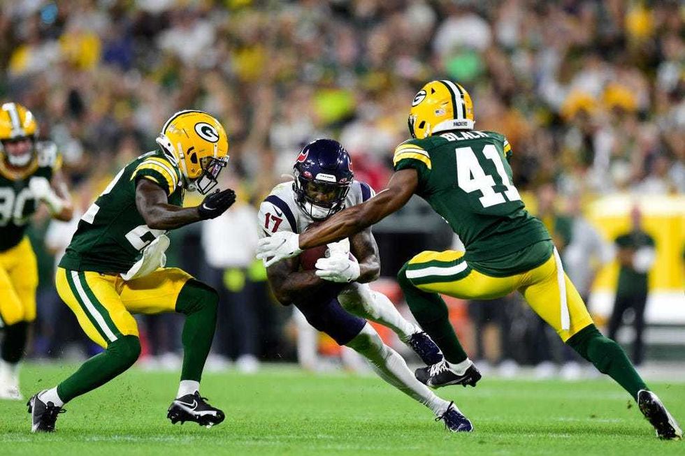 Anthony Miller #17 of the Houston Texans is tackled by Henry Black #41 of the Green Bay Packers in the first half during the preseason game at Lambeau Field on August 14, 2021 in Green Bay, Wisconsin.