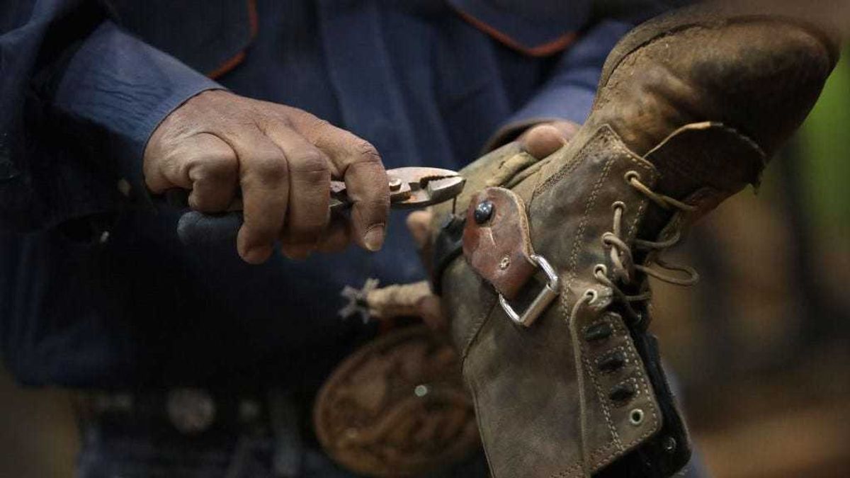 Anthony Monts repairs a spur on the boot of his son, Bull rider Anthony Monts Jr. at the Bill Pickett Invitational Rodeo on March 31, 2017 in Memphis, Tennessee.