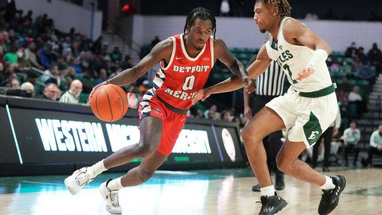 Antoine Davis #0 of the Detroit Mercy Titans dribbles by Noah Farrakhan #2