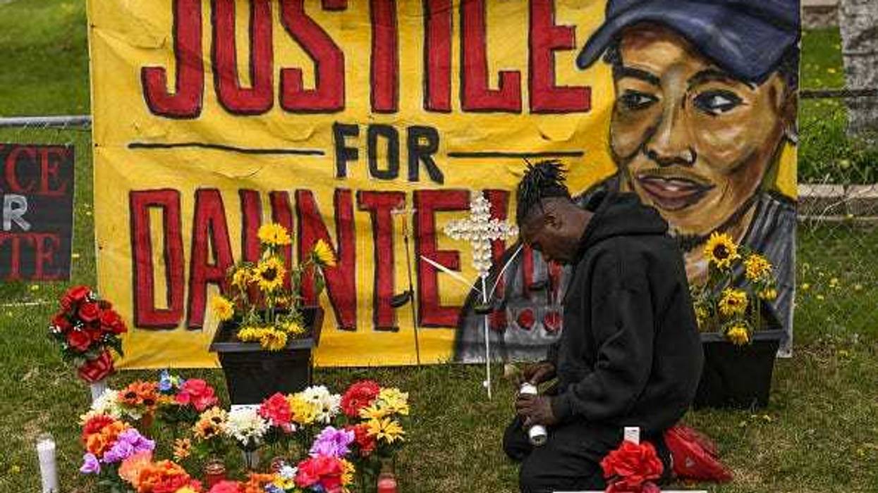 Antwon Davis lights candles at a memorial for Daunte Wright.