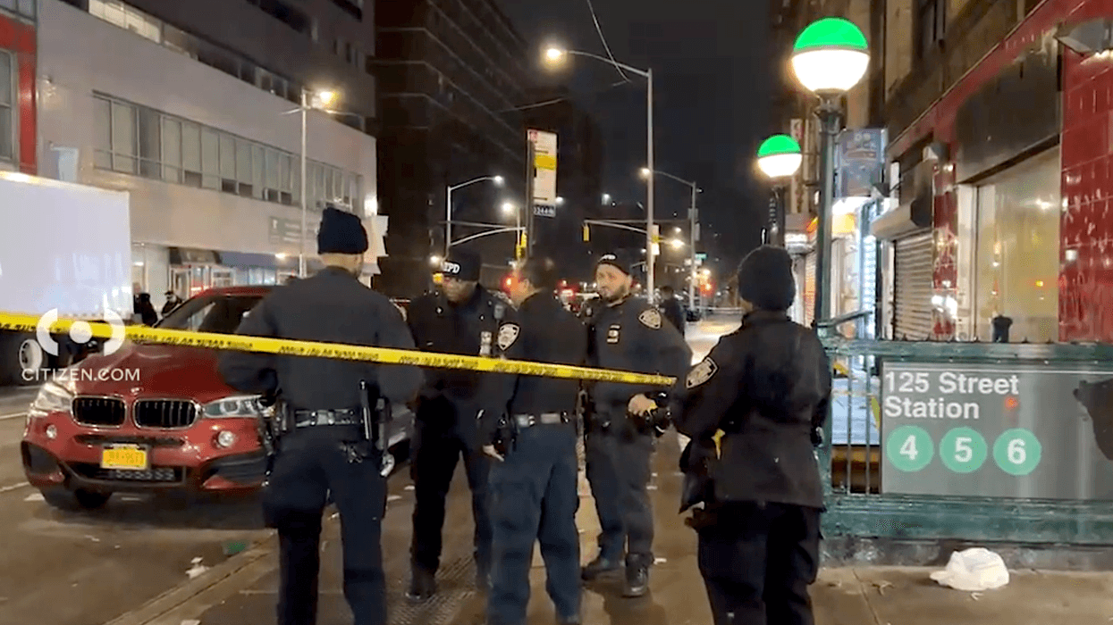 aNYPD officers are seen outside the East Harlem station where a man was shot early Friday