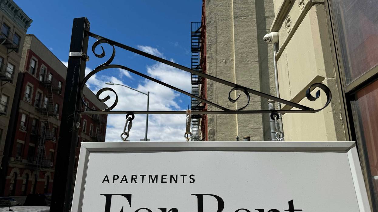 "Apartments for Rent" shingle hanging from a residential building in Harlem.