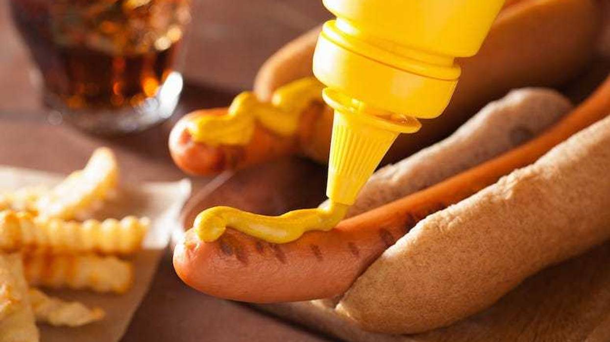 Applying mustard to a hot dog