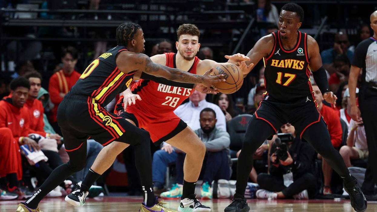 Apr 10, 2022; Houston, Texas, USA; Atlanta Hawks guard Delon Wright (0) and forward Onyeka Okongwu (17) attempt to steal the ball from Houston Rockets center Alperen Sengun (28) during the fourth quarter at Toyota Center.