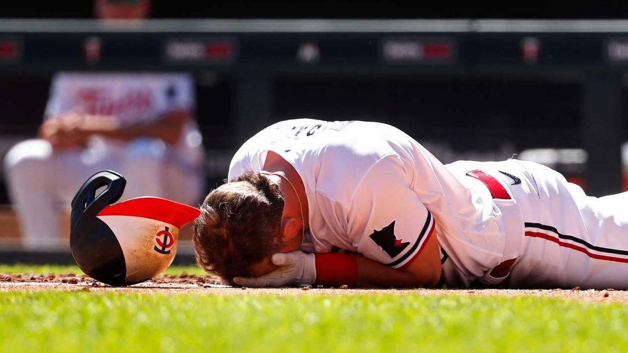 Apr 12, 2023; Minneapolis, Minnesota, USA; Minnesota Twins second baseman Kyle Farmer (12) drops to the ground after getting hit by a pitch in the face by the Chicago White Sox in the fourth inning at Target Field.