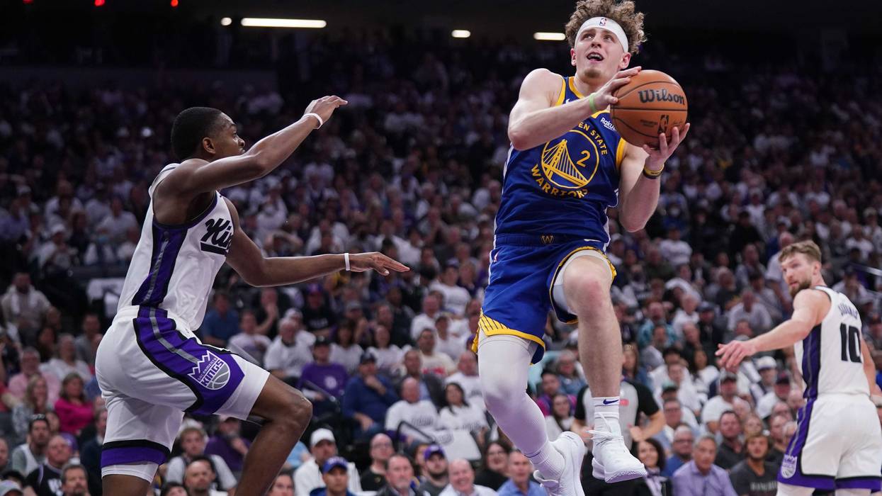 Apr 16, 2024; Sacramento, California, USA; Golden State Warriors guard Brandin Podziemski (2) makes a layup next to Sacramento Kings guard De'Aaron Fox (5) in the second quarter during a play-in game of the 2024 NBA playoffs at the Golden 1 Center.