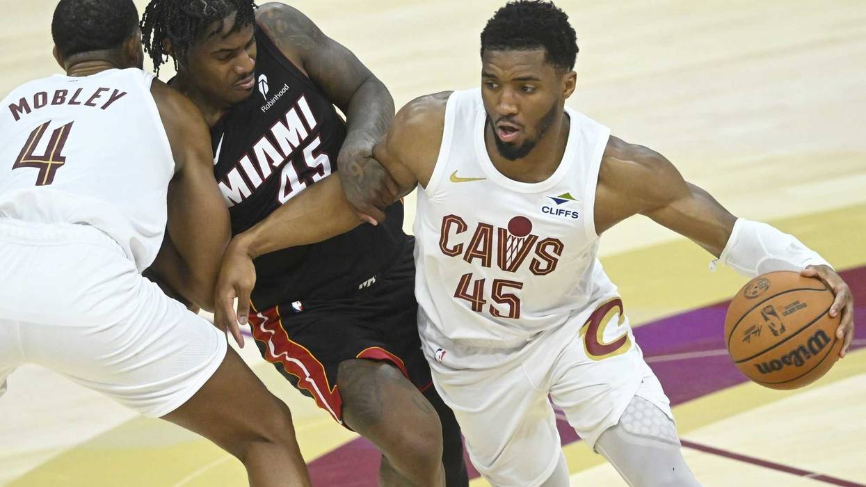 Apr 23, 2025; Cleveland, Ohio, USA; Cleveland Cavaliers forward Evan Mobley (4) sets a pick as guard Donovan Mitchell (45) dribbles around Miami Heat guard Davion Mitchell (45) in the fourth quarter of game two of the first round of the 2025 NBA Playoffs at Rocket Arena.