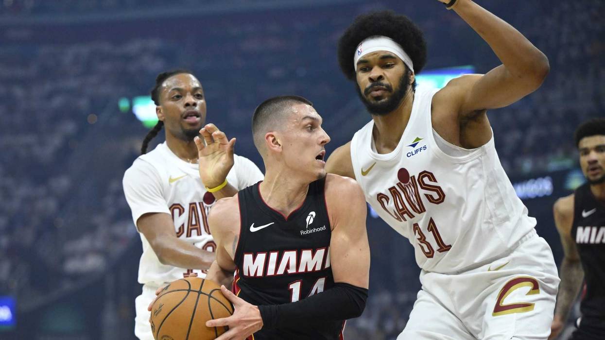 Apr 23, 2025; Cleveland, Ohio, USA; Miami Heat guard Tyler Herro (14) dribbles between Cleveland Cavaliers guard Darius Garland (10) and center Jarrett Allen (31) in the first quarter of game two of the first round of the 2025 NBA Playoffs at Rocket Arena.