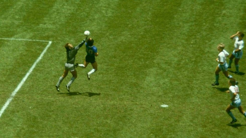 Argentina player Diego Maradona outjumps England goalkeeper Peter Shilton to score with his