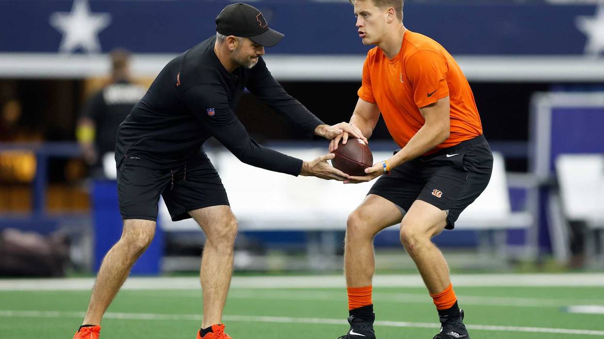 ARLINGTON, TEXAS - SEPTEMBER 18: Joe Burrow #9 of the Cincinnati Bengals runs warmup drills with quarterbacks coach Dan Pitcher before the game against the Dallas Cowboys at AT&T Stadium on September 18, 2022 in Arlington, Texas.