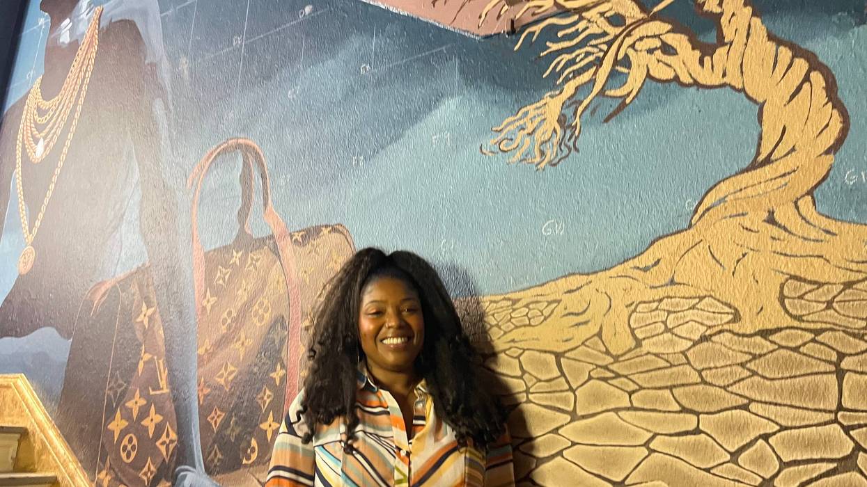 Artist Kelley Prevard standing in front of her mural.