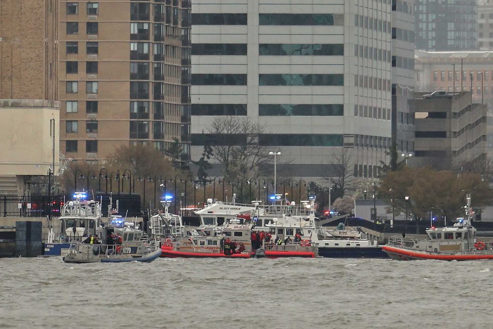 As seen from Pier 40 in New York, police and fire crews from New York and New Jersey respond to the scene Thursday, April 10, 2025, where a helicopter went down in the Hudson River between Manhattan and the New Jersey waterfront.