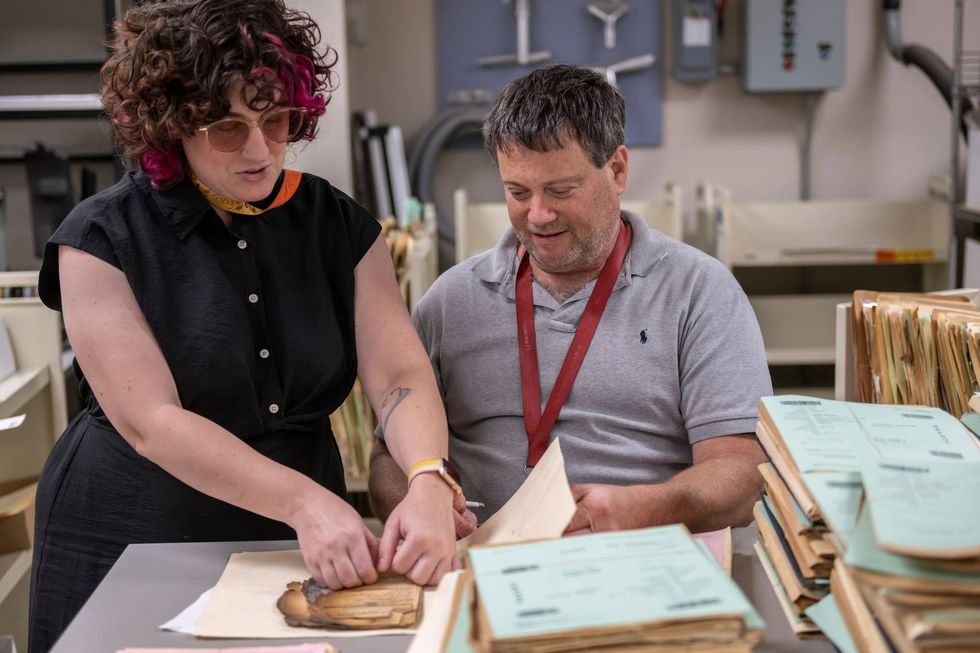 Ashley Cox, a preservation specialist at the National Archives and Records Administration, and NARA Preservation Technician Tom Schmidt assess a record