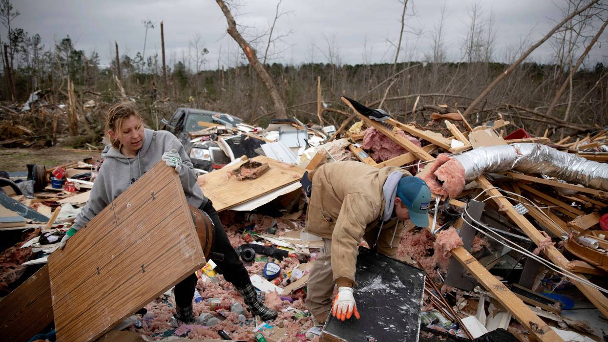 Ashley Griggs, left, helps Joey Roush sift through what is left of his mother's home after it was destroyed by a tornado in Beauregard, Ala., Monday, March 4, 2019.