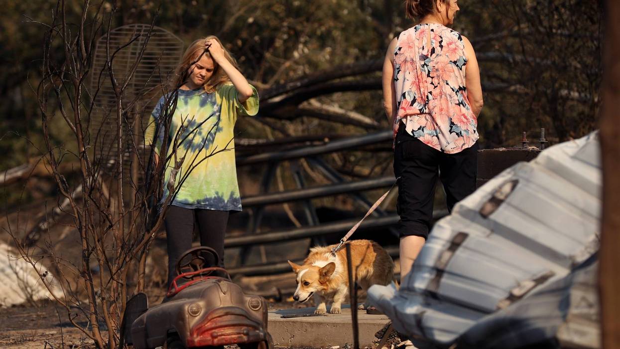 Ashley LaFranchi (L) and Stephanie LaFranchi (R) walk through a family home that was destroyed by the Kincade Fire on October 28, 2019 in Calistoga.