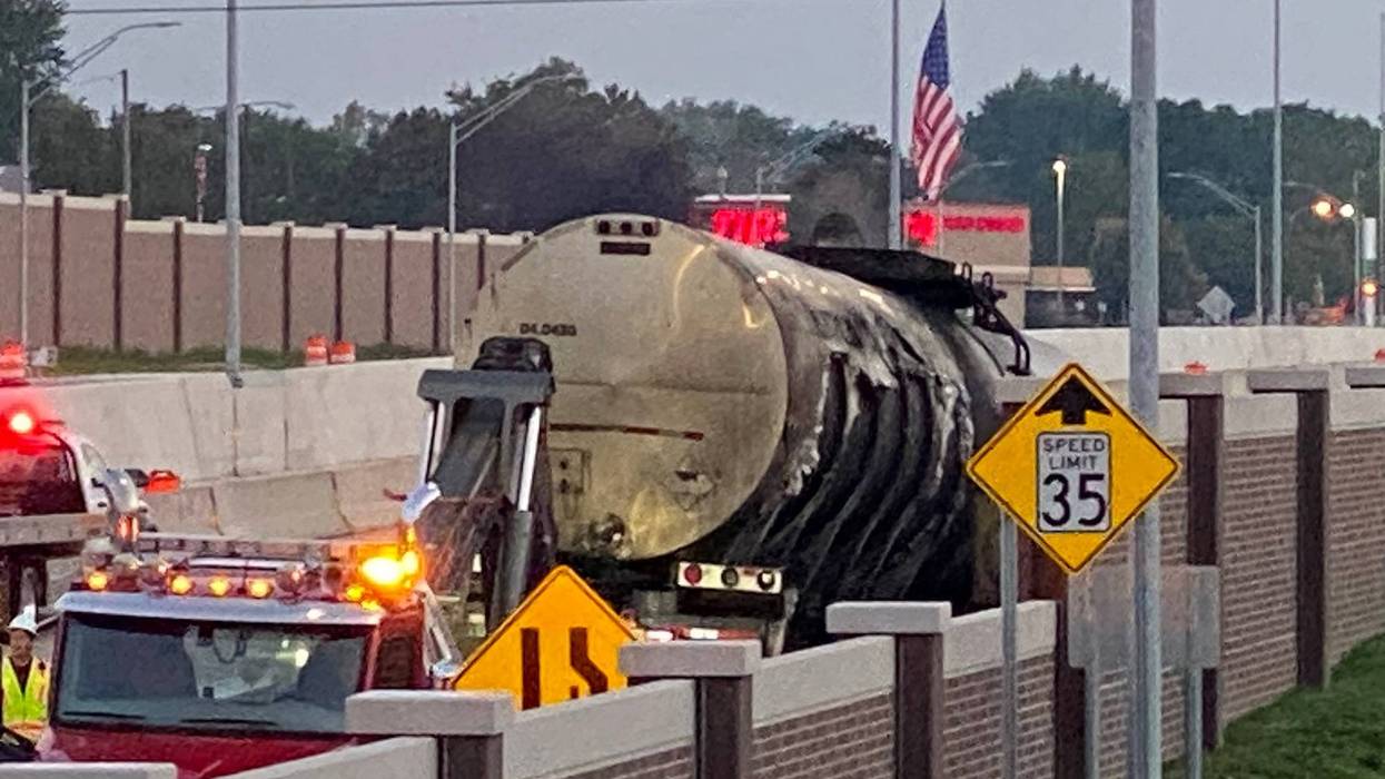 Asphalt tanker that caught fire on I-75 N at I-696 more than 12 hours ago. Workers transferred material to two other tankers, preparing to move burned one off the freeway.