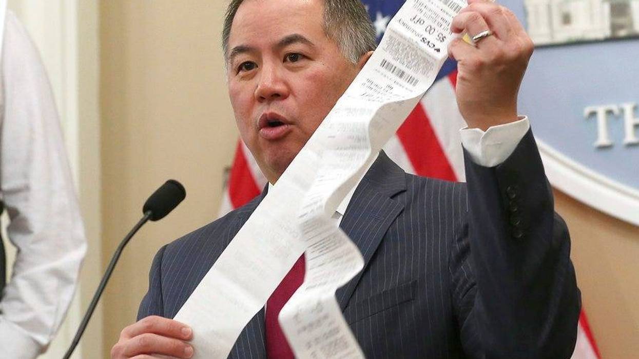 Assemblyman Phil Ting, D-San Francisco, displays a long paper receipt
