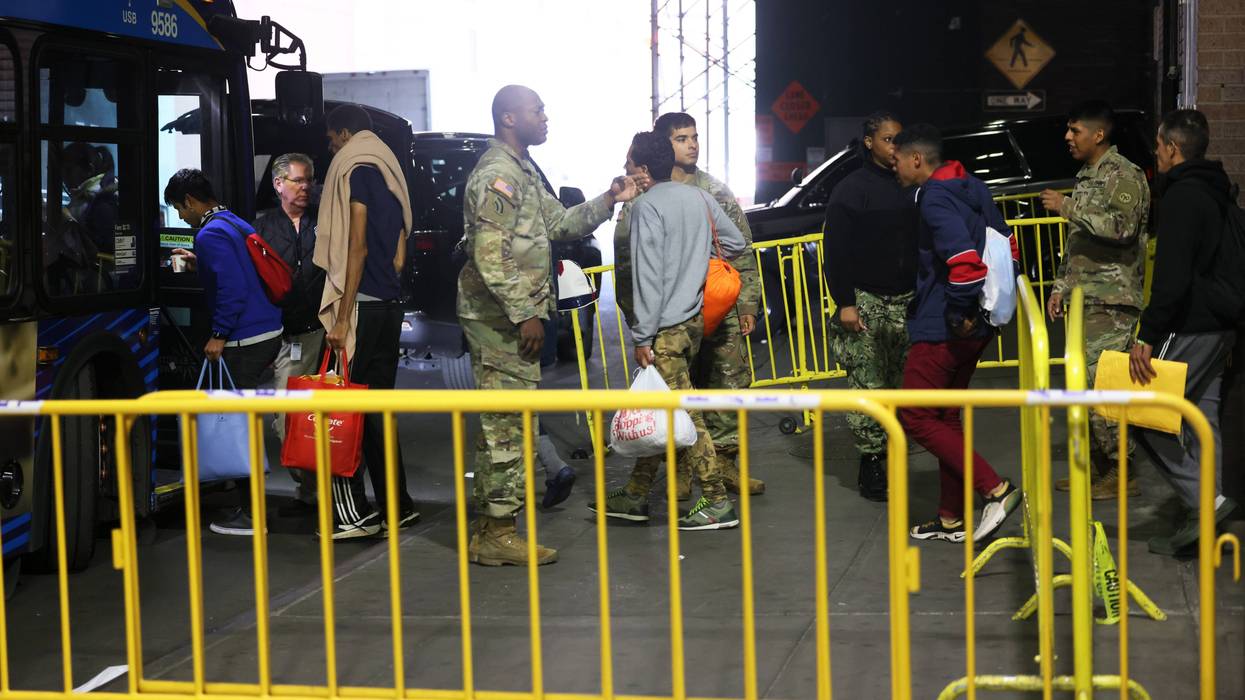 Asylum seekers board a bus en route to a shelter at Port Authority Bus Terminal on May 18, 2023, in New York City.