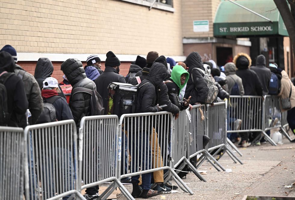 Asylum seekers line up in front of the East Village re-intake, converted into a city-run shelter for newly arrived migrant families, on Dec. 4, 2023