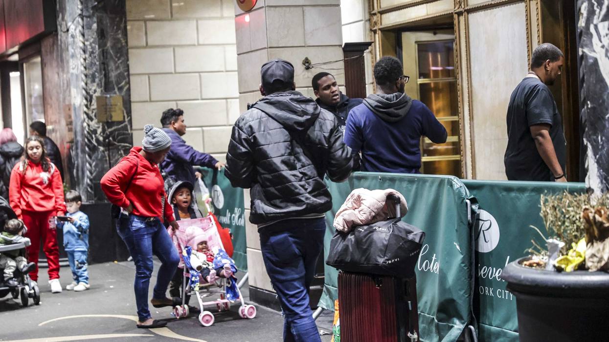Asylum seekers line up in front of the historic Roosevelt Hotel, which has been converted into a city-run shelter, on Sept. 27, 2023.