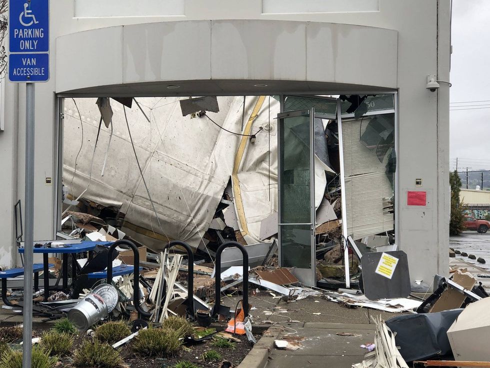 At 3:50 a.m., the roof over one corner of the warehouse caved, likely due to the weight of rainwater. As all the water rushed out of the building it ripped the front doors off, carrying chunks of drywall and pieces of office furniture into the parking lot.