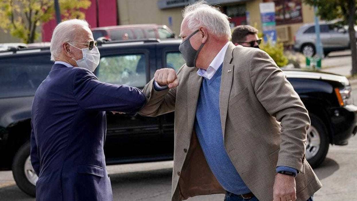 At the time, Democratic presidential nominee and former Vice President Joe Biden bumps elbows with Minnesota Governor Tim Walz in 2020 in Duluth, Minnesota.