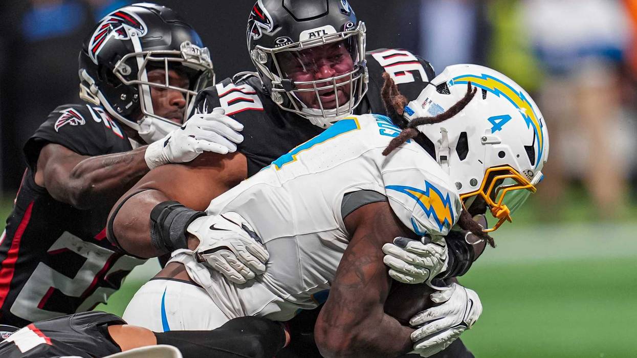 Atlanta Falcons defensive tackle David Onyemata (90) and cornerback Clark Phillips III (22) tackle Los Angeles Chargers running back Gus Edwards