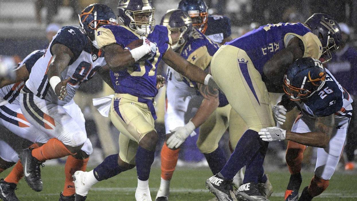 Atlanta Legends running back Lawrence Pittman rushes in front of Orlando Apollos defensive end Anthony Moten Jr. during the second half of an Alliance of American Football game Saturday, Feb. 9, 2019 in Orlando, Florida.