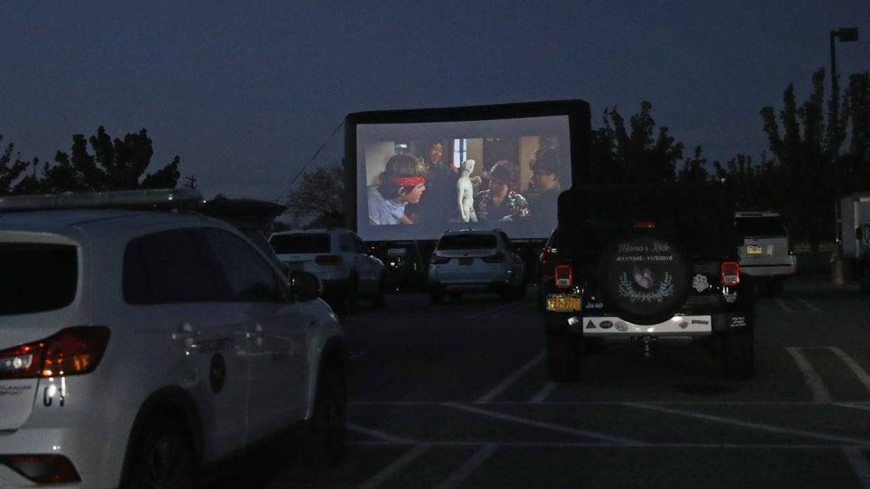 Attendees watch the movie "The Goonies" at a pop-up drive-in theatre built in the parking lot at the Broadway Commons on May 21, 2020 in Hicksville, New York.