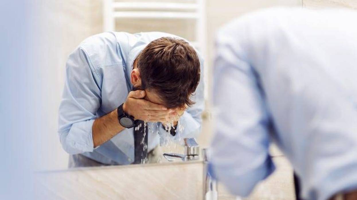 Attractive man washing his face