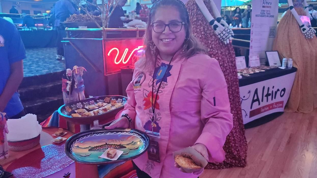 Atzimba Perez, owner and founder of Atzimba Catering, holds her food featured at Pilsen Gourmet.