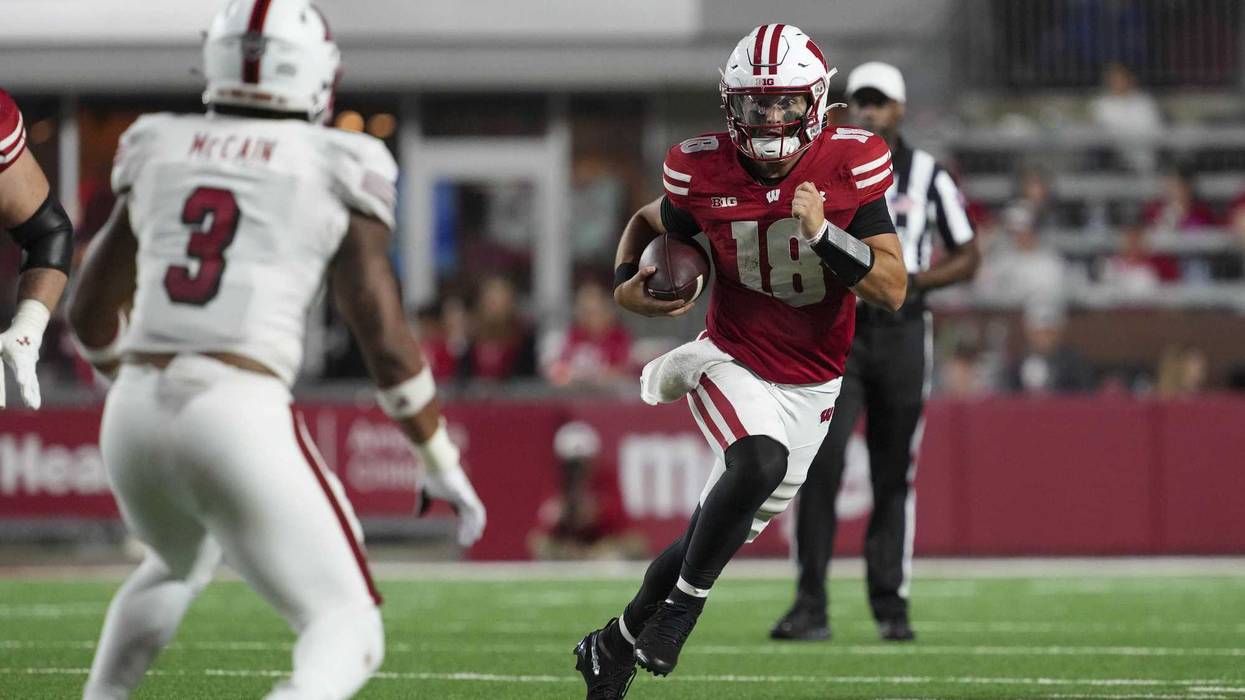 Aug 28, 2025; Madison, Wisconsin, USA; Wisconsin Badgers quarterback Danny O'Neil (18) rushes with the football as Miami (OH) RedHawks linebacker Malcolm McCain (3) defends during the third quarter at Camp Randall Stadium. Mandatory Credit: Jeff Hanisch-Imagn Images