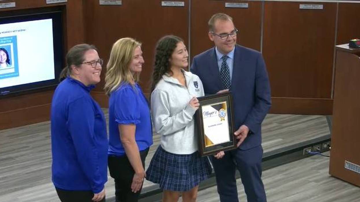 Aurora high school student poses for pictures with Aurora's mayor.