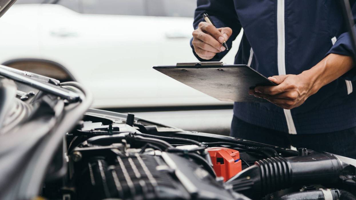 Automobile mechanic repairman hands repairing a car engine automotive workshop
