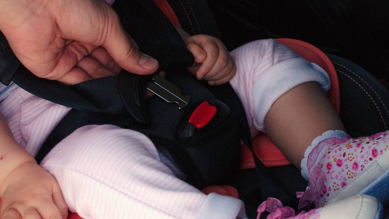 baby strapped into car seat