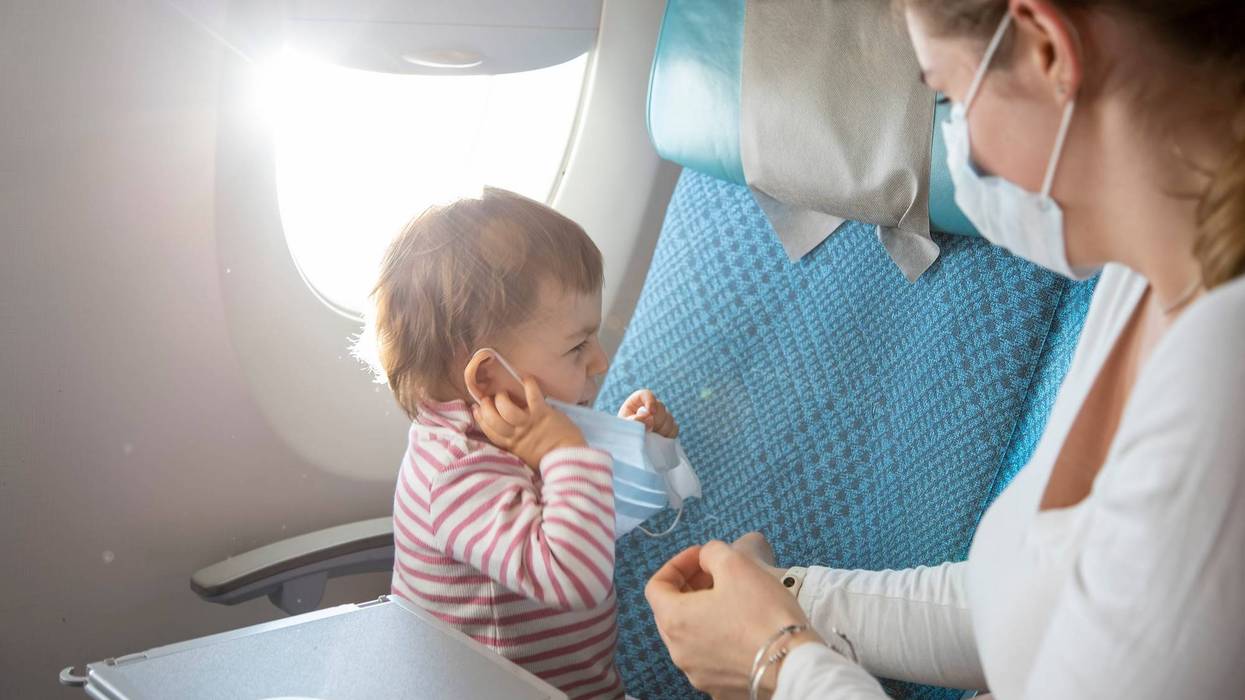 Baby with mask on plane stock photo