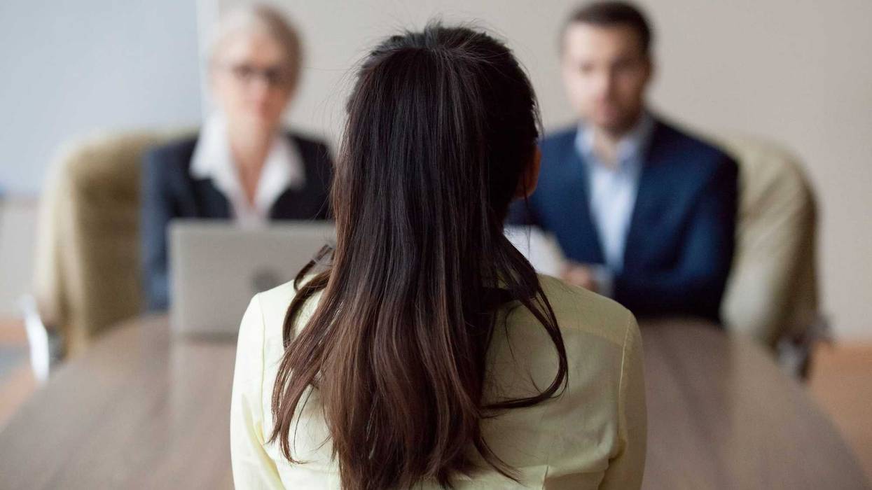 Back of woman's head as she speaks to her bosses.