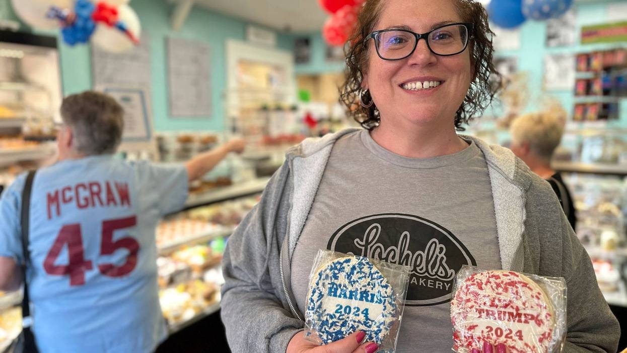 Bakery owner Kathleen Lochel holds sugar cookies, one with blue and white sprinkles and a Harris 2024 label on it and the other, with red and white sprinkles and a Trump 2024 label on it in Lochel Bakery, Tuesday, Sept. 24, 2024, in Hatboro, a suburb of Philadelphia.